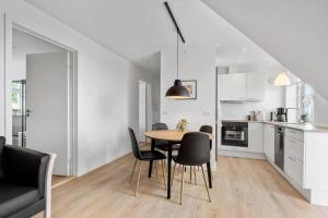 a kitchen and dining room with a table and chairs at N005-Nysted-Gammel-Torv-4-A-2-th in Nysted