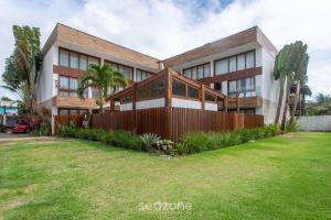 a house with a fence in front of a yard at CPR - Apartamentos a 200m da praia com Piscina in Marau +37 photos