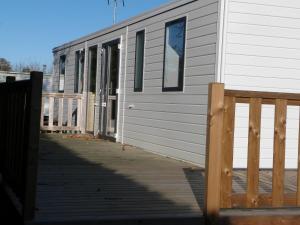 un edificio blanco con una valla de madera al lado en Mobilhome 4 chambres 8 places, en Erquy