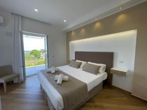a bedroom with a large bed with a large window at Relais Villa Verde in Ventotene
