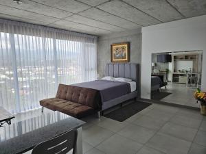 a bedroom with a bed and a couch at Urban Breeze iFreses, 10th floor! AC, TV and Pool in Guayabos