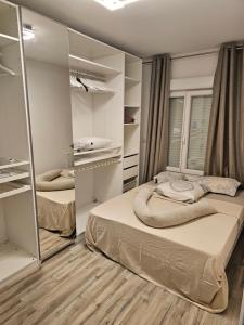 ein Schlafzimmer mit zwei Betten und einem Spiegel in der Unterkunft Emmanuel INN 3 in Drancy