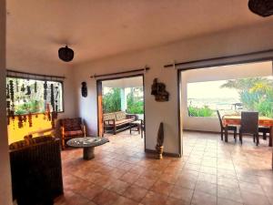a living room with a table and chairs and sliding doors at Bungalow accés direct plage privée "Plage tropicale Chez Jack et Régine" in Grand-Bassam