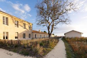 a dirt road next to a building and a tree at Plages à 50m - Spacieux appartement T4 - 8 couchages - résidence premium au calme - nature, village et port à pieds in Boyardville