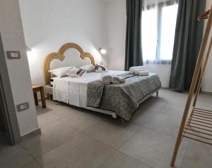 ein Schlafzimmer mit einem großen Bett und einem Fenster in der Unterkunft Domus Alba in Teulada