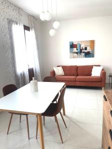 - un salon avec une table blanche et un canapé rouge dans l'établissement Domus, à Teulada