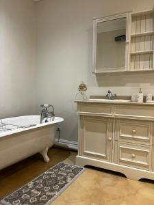 a bathroom with a tub and a sink and a mirror at Aviemore Farmhouse in Nottingham Road +84 photos