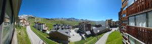 a view of a city with buildings and a mountain at Le Serac Panoramic Mountain View spacious 40m2 managed by private host in Val Thorens