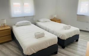 Dos camas en una habitación con sábanas y almohadas blancas. en SwordFish Charming Retreat, en Peniche