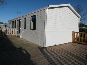 un edificio blanco con una puerta en una cubierta en Mobilhome 4 chambres 8 places, en Erquy