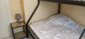 ル・ヴェルドン・シュル・メールにあるLa Villa des Dunes à la Plage Chambretteのランプのある小さな部屋の空のベッド