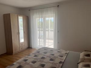une chambre avec un lit et une grande fenêtre dans l'établissement Apartment Niva, à Nin