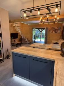 a kitchen with a blue island in a room at Z duszą i parą, dom z ogrodem i sauną na wyłączność, obok Poleskiego Parku Narodowego in Dębowiec