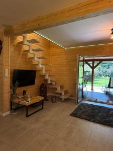 a living room with a wooden wall with a staircase at Z duszą i parą, dom z ogrodem i sauną na wyłączność, obok Poleskiego Parku Narodowego in Dębowiec