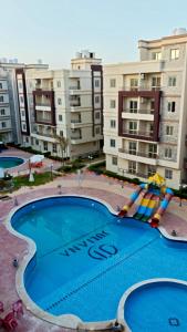 a large swimming pool in front of some buildings at VIP Chalet at JULIANA North coast جوليانا الساحل الشمالي in Dawwār Muşādif Yūnus