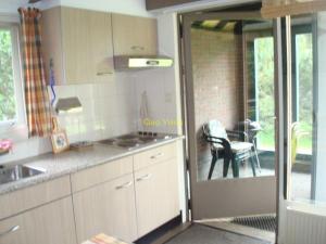 a kitchen with a door open to a patio at Quo Vadis vakantiehuis Lengel in Lengel