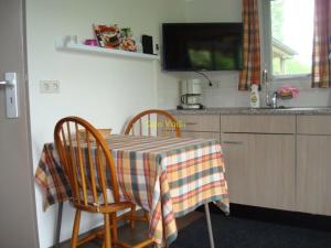 a kitchen with a table and two chairs with a tablecloth at Quo Vadis vakantiehuis Lengel in Lengel +3 photos