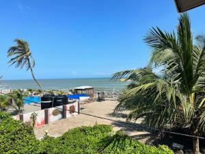 una spiaggia con una palma e l'oceano di Coconut Pointe Villa & Beach Resort a Prampram