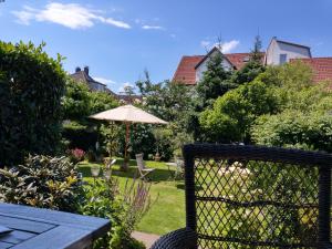 a patio with an umbrella and a table and chairs at Moderne Ferienwohnung in Bad Salzuflen - Zentrale Lage & Wohlfühlkomfort in Bad Salzuflen