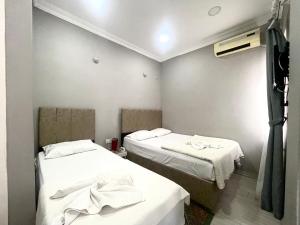 伊斯坦布尔优思明酒店的小客房内的两张床,配有白色床单