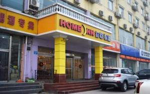 a store front with a yellow and purple building at Home Inn Shijiazhuang Railway Station West Square South Zhonghua Street in Shijiazhuang