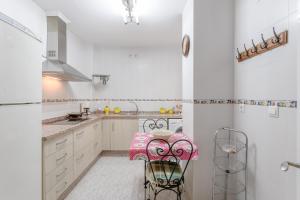 Una cocina con gabinetes blancos y una mesa y sillas. en Villa Gallardo, en Campillos
