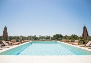 a swimming pool with chairs and umbrellas at Cervino in Ulcinj