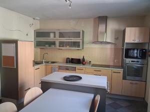 a kitchen with wooden cabinets and a white counter top at Suite parentale et cuisine in Parthenay