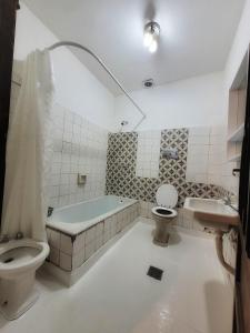 a bathroom with a toilet and a tub and a sink at Cómo en casa, cerca de todo, amplio 100m2 in San Miguel de Tucumán