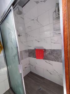 a bathroom with a shower with a red towel at Casa de campo San Marcos in Pujilí