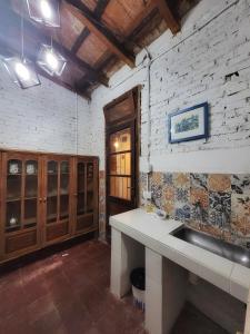 a kitchen with a sink and a brick wall at Cómo en casa, cerca de todo, amplio 100m2 in San Miguel de Tucumán