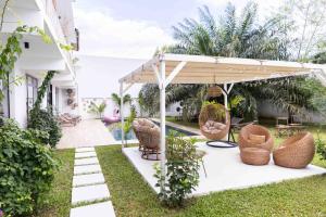 アビジャンにあるGoya Resorts & SPAの椅子とテーブルが置かれたパビリオンのある庭園