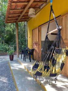a hammock hanging from the side of a house at Chalés Borborema Cumuru in Prado