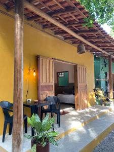 a patio with a table and chairs and a room at Chalés Borborema Cumuru in Prado +159 photos