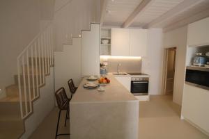 a kitchen with a counter with chairs and a sink at Casa Di Benedetta in Gallipoli