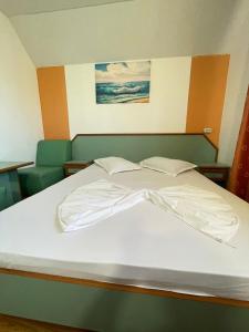 a large white bed in a room with a painting at Vila Pajura in Costinesti