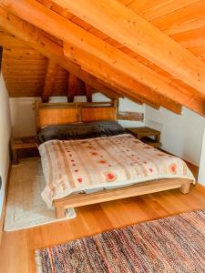 a bed in a room with a wooden ceiling at Casa Tre Fonti in Baselga di Pinè