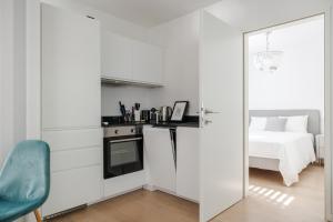 Una habitación blanca con una cama y una cocina. en Stylish City Suite, Balcony, Augarten & Center, en Viena 20 fotos más