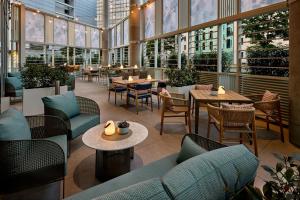 a restaurant with tables and chairs and windows at Courtyard by Marriott Berlin City Center in Berlin