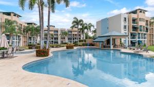 uma piscina num resort com palmeiras e edifícios em Tropical Escape With Pool Tennis Cabo Rojo em Cabo Rojo