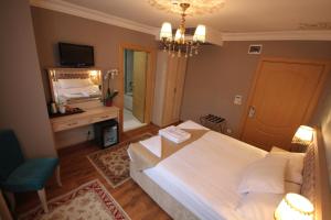 una camera da letto con un grande letto bianco e uno specchio di Sultans Royal Hotel a Istanbul
