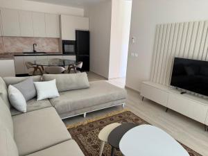 a living room with a couch and a table at Everbright Seaside Serenity in Himare