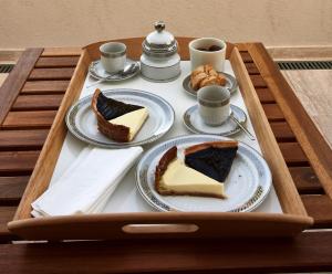スカルリーノにあるA CASA DI LEO B&B Country Houseのケーキの皿とコーヒーカップが載ったトレイ