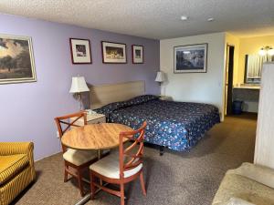 a hotel room with a bed and a table at Federal Way Motel in Federal Way