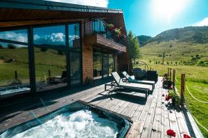 a house with a hot tub on a wooden deck at Mon Amor Chalet in Şirnea