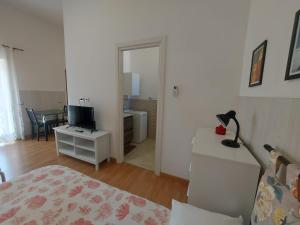 a bedroom with a bed and a desk with a television at Appartamento Aurora Pro in Altamura +4 photos