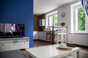 コウォブジェクにあるSantoriniの青い壁にテレビ付きのリビングルーム