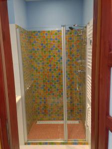 un bagno con doccia con piastrelle colorate di Lake View Apartments at Golf Resort Kunětická Hora, Dříteč a Bukovina Altre 34 foto
