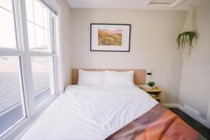 レジャイナにあるCozy & Stylish Laneway suiteの窓のある部屋にある白いベッド