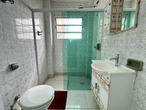 ein Badezimmer mit Dusche, Toilette und Waschbecken in der Unterkunft Guilhermina – apto pertinho da praia in Praia Grande